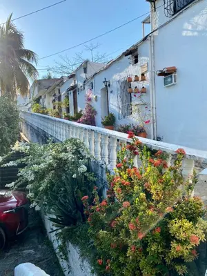 a white house with flowers on a fence at Cabaña La Aldea - Santorini Colombiano in Doradal