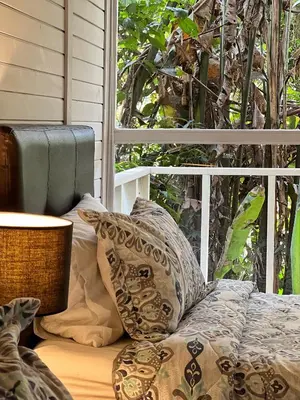 a bed with pillows sitting next to a window at Finca Turística de Alojamiento Rural Avalon in Jardin
