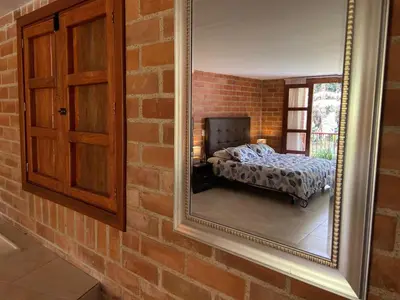 a mirror on a brick wall next to a bedroom at Finca Turística de Alojamiento Rural Avalon in Jardin