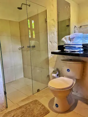 a bathroom with a toilet and a glass shower at Finca Turística de Alojamiento Rural Avalon in Jardin