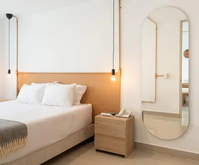 a bedroom with a bed and a mirror at Hotel Santa Ana Medellin in Medellín
