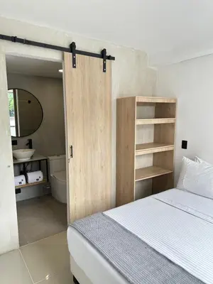 a bedroom with a bed and a bathroom with a mirror at Hotel Santa Ana Medellin in Medellín
