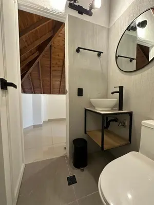 a bathroom with a sink and a mirror at Hotel Santa Ana Medellin in Medellín