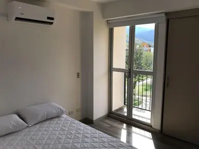a bedroom with a bed and a large window at Apartasol de Lujo Santa Fe de Antioquia