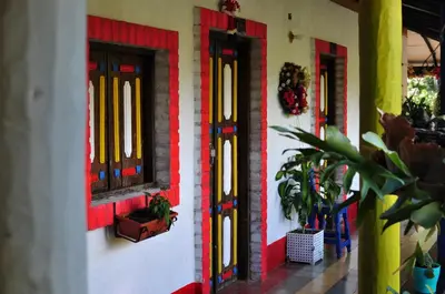 a building with red and yellow doors and plants at La Kolorina hotel campestre in Jericó