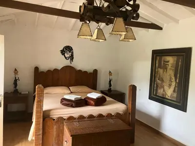 a bedroom with a bed and a picture on the wall at La Kolorina hotel campestre in Jericó
