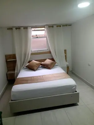 a bed in a room with a window and a bedvisor at Hotel Gutier Rionegro in Rionegro