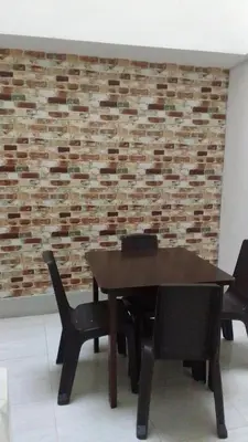 a wooden table and chairs in front of a brick wall at Hotel Gutier Rionegro in Rionegro