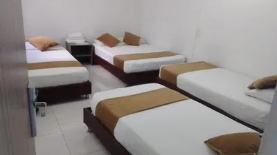 a room with four beds in a room at Hotel Gutier Rionegro in Rionegro