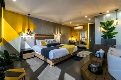 a bedroom with a bed and a bathroom with a tub at Epic Boutique Hotel in Medellín