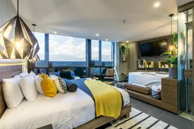 a bedroom with a large bed with a tub and a bathroom at Epic Boutique Hotel in Medellín