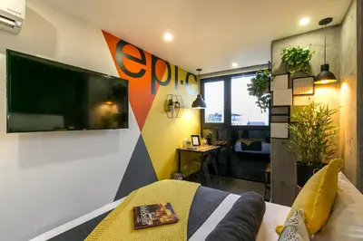 a living room with a tv on a wall at Epic Boutique Hotel in Medellín