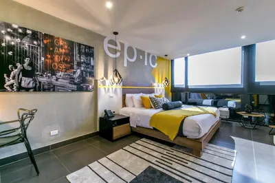 a bedroom with a bed with a yellow blanket at Epic Boutique Hotel in Medellín