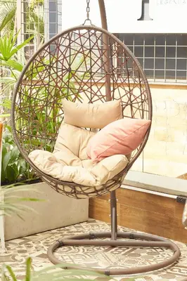 a rattan chair with pillows on a patio at Epic Boutique Hotel in Medellín