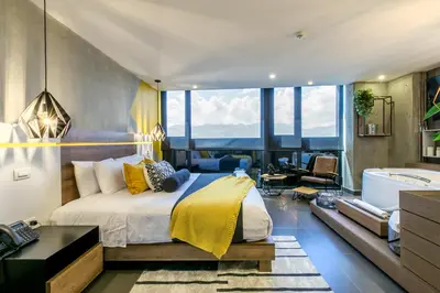 a bedroom with a large bed and a tub in a room at Epic Boutique Hotel in Medellín