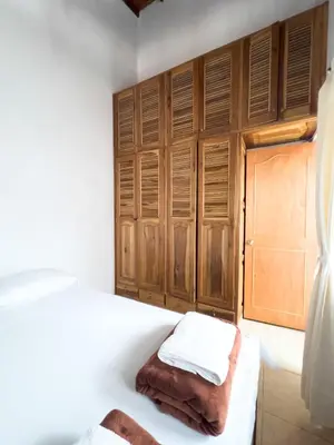 a bedroom with two beds and wooden cabinets at Apartamentos Primavera in Jardin