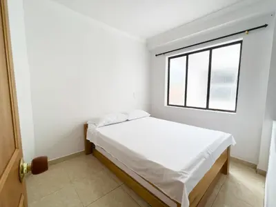a small bedroom with a bed and a window at Apartamentos Primavera in Jardin