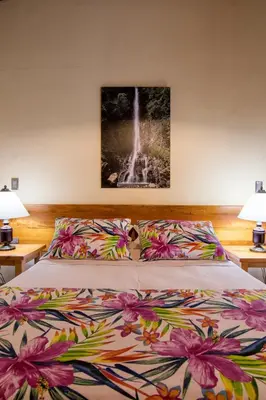 a bedroom with a bed with a flowered comforter at Hotel Valdivia Plaza in Jardin