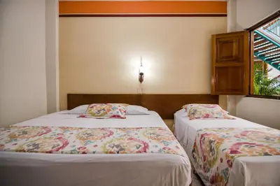 a bedroom with two beds and a window at Hotel Valdivia Plaza in Jardin