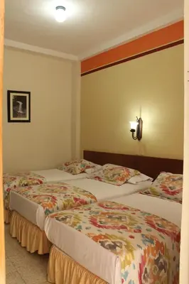 two beds in a hotel room at Hotel Valdivia Plaza in Jardin