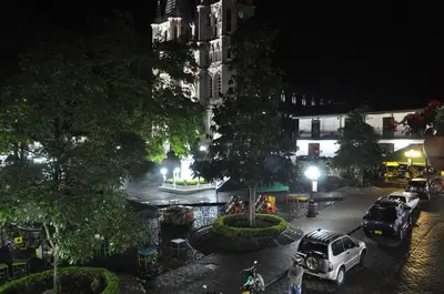 a city street at night with cars parked at Hotel Valdivia Plaza in Jardin