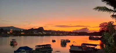a sunset over a body of water with boats at Hotel Real Guatapé in Guatapé
