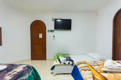 a bedroom with a bed and a tv on the wall at Hotel Real Guatapé in Guatapé