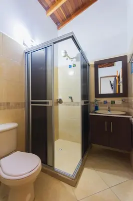 a bathroom with a shower with a toilet and a sink at Hotel Real Guatapé in Guatapé