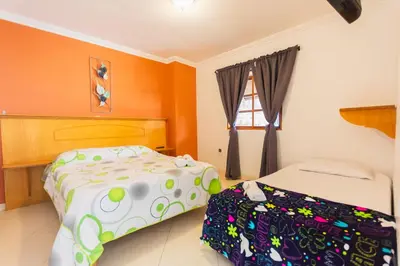 a bedroom with two beds and a window at Hotel Real Guatapé in Guatapé