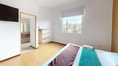 a white room with a bed and a window at Hotel Villa Colonia in Marinilla