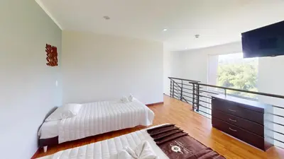 a bedroom with two beds and a balcony at Hotel Villa Colonia in Marinilla