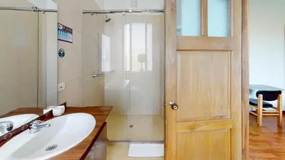 a bathroom with a shower and a sink and a door at Hotel Villa Colonia in Marinilla