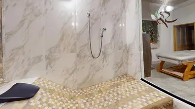 a bathroom with a shower with a bench in it at Hotel Villa Colonia in Marinilla