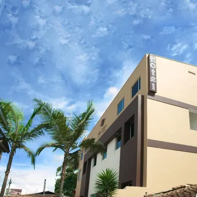 a building with palm trees in front of it at Hotel Villa Colonia in Marinilla
