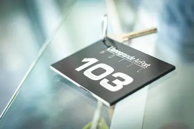 a black and white sign on a glass table at Llanogrande Airport by Bernalo Hotels in Rionegro