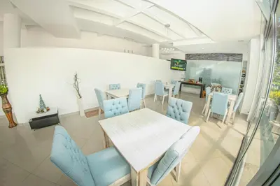 a dining room with a table and blue chairs at Llanogrande Airport by Bernalo Hotels in Rionegro