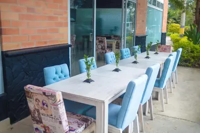 a row of tables and chairs with plants on them at Llanogrande Airport by Bernalo Hotels in Rionegro