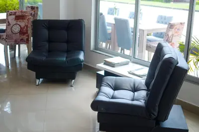 a living room with two chairs and a couch at Llanogrande Airport by Bernalo Hotels in Rionegro