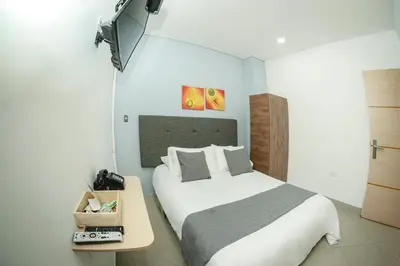 a bedroom with a large bed and a table at Llanogrande Airport by Bernalo Hotels in Rionegro