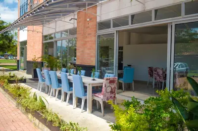 a table and chairs sitting outside of a building at Llanogrande Airport by Bernalo Hotels in Rionegro