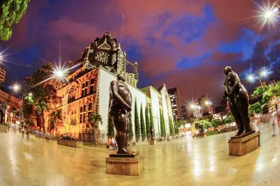 two statues in front of a building with lights at NH Collection Medellin Royal in Medellín