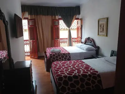 a hotel room with two beds and a window at Bonsai Hotel Salamina Caldas in Salamina