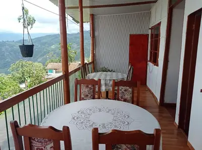 a dining room with a table and chairs on a balcony at Bonsai Hotel Salamina Caldas in Salamina