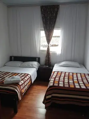 two beds sitting in a room with a window at Bonsai Hotel Salamina Caldas in Salamina