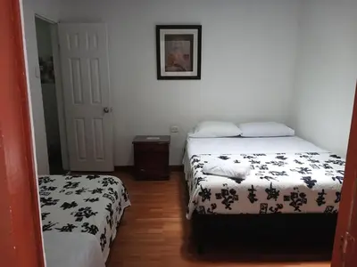a bedroom with two beds and a door to a room at Bonsai Hotel Salamina Caldas in Salamina