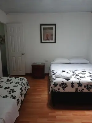 a bedroom with two beds and a picture on the wall at Bonsai Hotel Salamina Caldas in Salamina