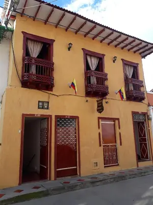 a yellow building with two balconies and flags on it at Bonsai Hotel Salamina Caldas in Salamina
