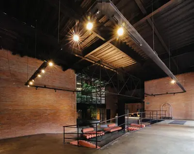 a large room with a brick wall and lights at The Art Hotel Medellin in Medellín