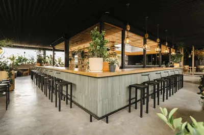 a bar with a bunch of stools in a restaurant at The Art Hotel Medellin in Medellín