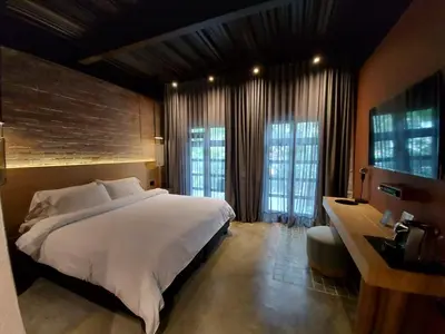 a bedroom with a large white bed and two windows at The Art Hotel Medellin in Medellín